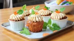 Sladké muffiny s krémem, mrkvovou ozdobou a čerstvou mátou na plechu