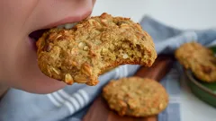 Kousnutí do domácího ovesného sušenky na dřevěném prkénku, detailní záběr