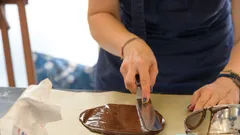 žena zdobí kus čokolády detailně
