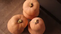 Oranžová dýně na černém stole při západu slunce